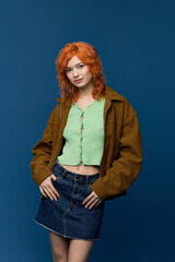 Spring style shines with a young woman showcasing vibrant fashion against a blue backdrop