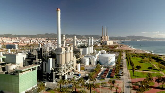 Thermal power plant working with natural gas to create electricity and power with european city of Barcelona in the background, energy infrastructure