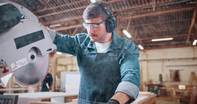 Bandsaw, carpentry and earmuffs with man in plant for manufacturing or production process. Eyewear, ppe and sawing machine with person in woodworking warehouse to resize lumber or timber for project