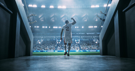 Star Player in White and Red Sports Uniform Walking Out of the Stadium Tunnel Before the Match. Talented Black African Football Player is Cheered by the Soccer Fans at a Professional Stadium