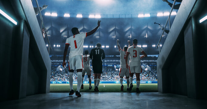 Male Soccer Players Stride From the Stadium Tunnel Onto the Game Field, Crowd Cheering World Championship Match Game at a Major Professional Arena Event.