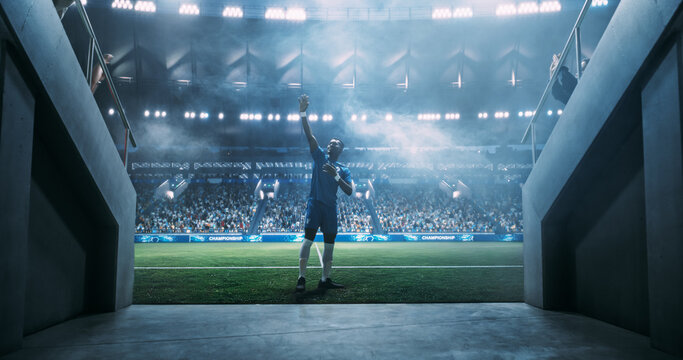 Black Male Soccer Player Walks From the Stadium Tunnel Onto the Field Waving to Fans Before a Professional Championship. Start of a Major League Match Game in a Large Arena Event. Cinematic Photo