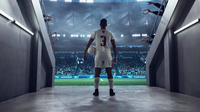 Soccer Player Pauses at the Stadium Tunnel Exit With Ball in Hand, Facing the Field and Full Arena Before Kickoff in a Professional International Football Euro World Event.