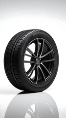 Obraz premium A close-up studio shot of a shiny, sleek black car tire on a reflective white surface