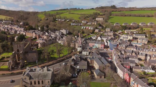 Drone view of Jedburgh, Scottish Borders buildings and hills on a sunny day