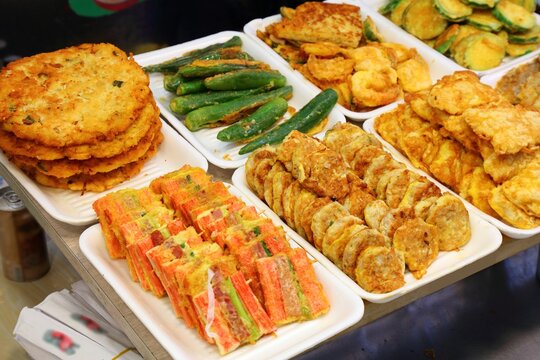 Korean food at traditional Gwangjang Market in Seoul, South Korea. Various deep fried foods including bindaetteok mung bean pancakes, fried batter vegetables and surimi.