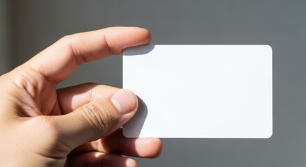 Fototapeta premium Hand holding blank card mockup against blurred background with copy space