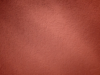 Fototapeta premium Textured wall surface in a warm shade observed during daylight hours