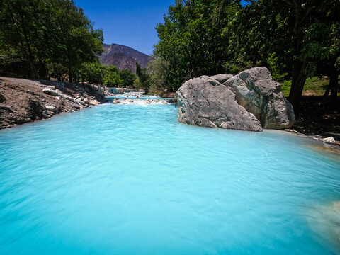 Discover a breathtaking turquoise river, a natural wonder. Perfect for your Mexico roadtrip, offering serene views among lush trees and ancient rocks