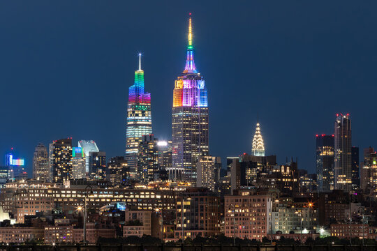 New York City, NY, USA - June 26, 2022: The Empire State Building and One Vanderbilt skyscrapers illuminated with rainbow colors for LGBTQ+ Pride week. Midtown, Manhattan