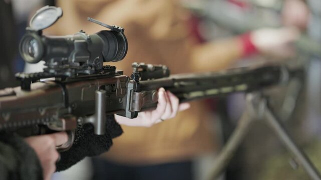 Person holding heavy machine gun with scope