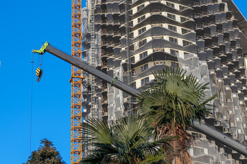 The retractable boom of the hydraulic crane on the base of the car. Equipment for the construction and lifting of bulky goods with construction materials. Construction of buildings. © Eduard Belkin