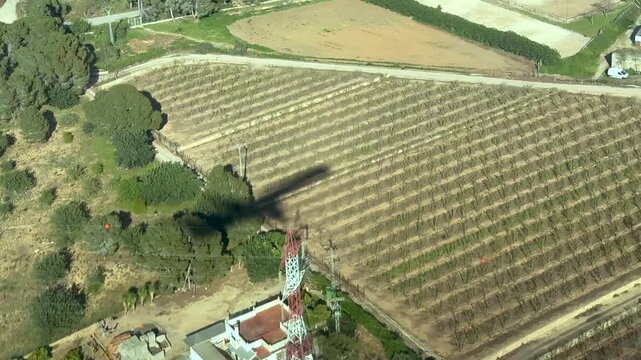 Aerilal cockpit view of the shadow of a medium size jet airplane on the ground in the final approach, crossing a highway