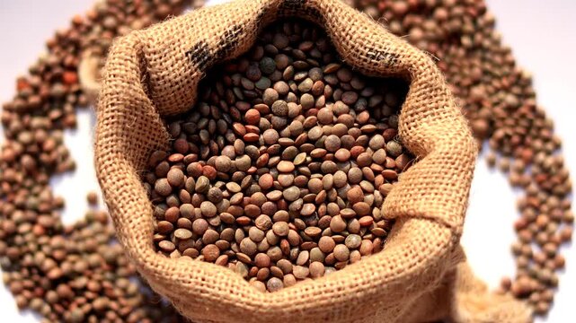 Black Lentil/ masoor dal filled in jute sack table top spin isolated on white background.