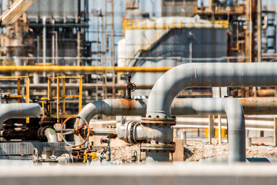 Industrial pipes, valve system inside refinery with metal structures, processing equipment in background. War Iran. Problems with oil supply, logistics. Kuwait, Strait of Hormuz, Kharg Island	