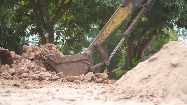 Excavator at Work: The excavator digs into the earth, a symphony of industrial power and construction might. The massive machine reshapes the land. 