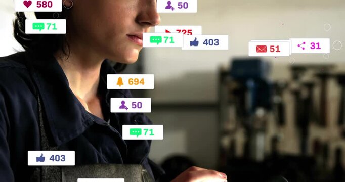 Female technician tapping tablet, sending badges floating across workshop, monitoring job updates