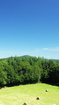 Scenic view of lush green hills, forests, and open fields under a clear blue sky in the Morvan region of France.