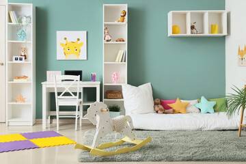 Naklejka na ściany i meble Comfortable bed, table and shelving units in interior of children's room