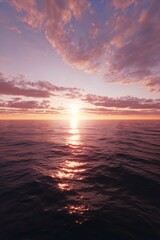 Obraz premium Peaceful sunset over calm ocean waters with a few clouds.