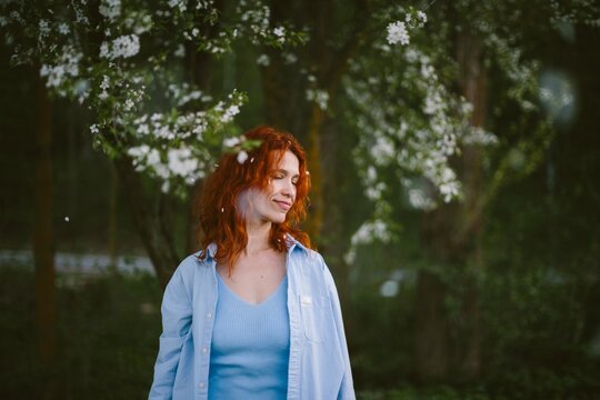 Woman enjoying spring with falling flower petals