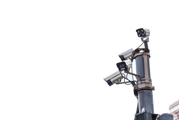 Fototapeta premium Multiple cctv security cameras mounted on a tall metal pole against a white sky background. concept of modern surveillance, public safety, urban security systems and monitoring technology.