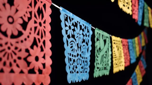 Colorful traditional Mexican papel picado banners against dark background