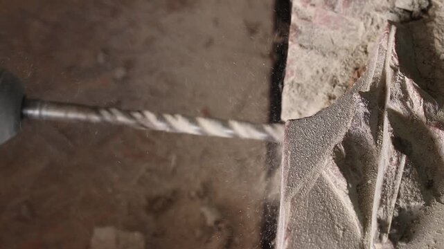 The process of drilling a hole with a concrete drill inserted into a perforator. Creating a hole in concrete or stone. The process of construction or repair. Close-up of the process of drilling a hole