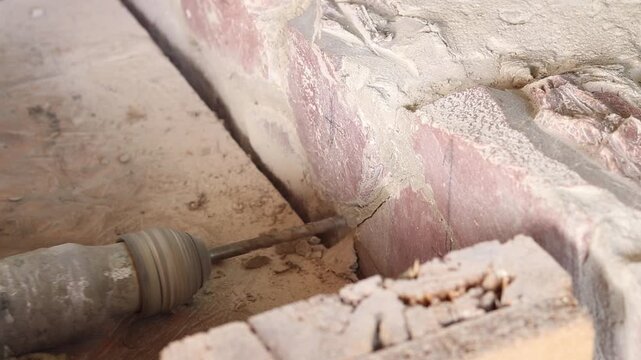 The process of drilling a hole with a concrete drill inserted into a perforator. Creating a hole in concrete or stone. The process of construction or repair. Close-up of the process of drilling a hole