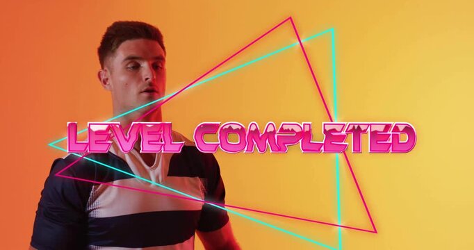 Animation of level completed text over neon pattern caucasian rugby player