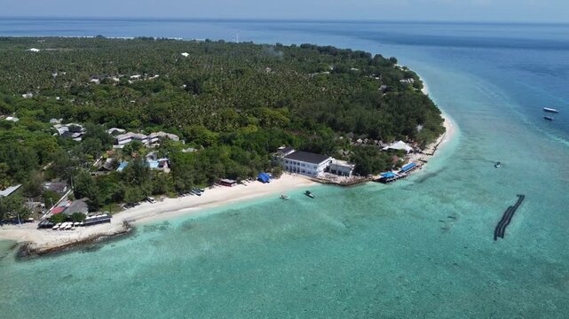 Cinematic aerial drone hovering then moving left along the shoreline of Gili Trawangan, Indonesia.