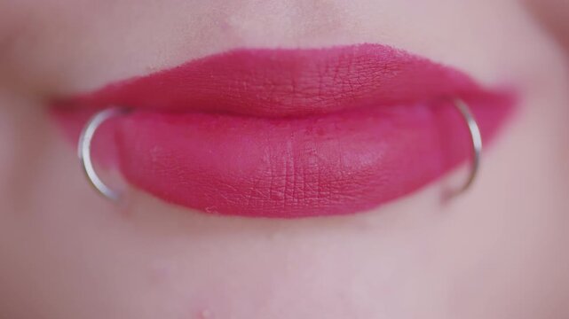 Woman's pink lips with snake bites piercing smiling