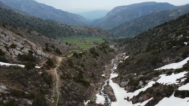 Aerial view of a hidden green meadow in a misty mountain gorge, metaphor for finding clarity, hope, and hidden opportunities.