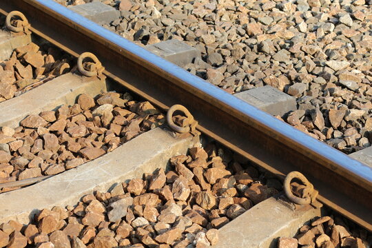 Close-up view of railway tracks with concrete sleepers and ballast stones