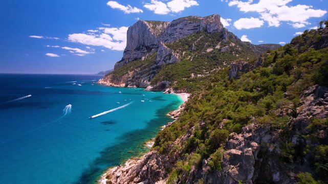 Italy Sardinia Aerial 4K Drone Video Reveal of Cala Sisine Beach Over Rocky Mountains and Limestone Cliffs Towards Big Sea Stack and Turquoise Bay Orosei Gulf Summer Travel