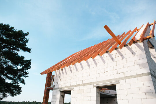 Contemporary house with wooden roof lags installed, brick and block walls, stropil system evolve, building covered by home insurance and construction loan.