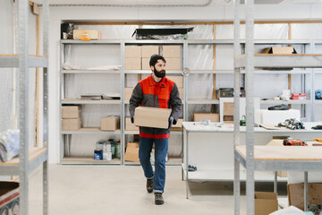 Fototapeta premium Worker carrying box in warehouse storage room