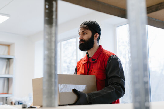 Worker carrying a cardboard box at a warehouse