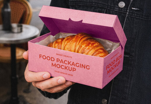 Hand Holding Food Packaging Box with Croissant Mockup