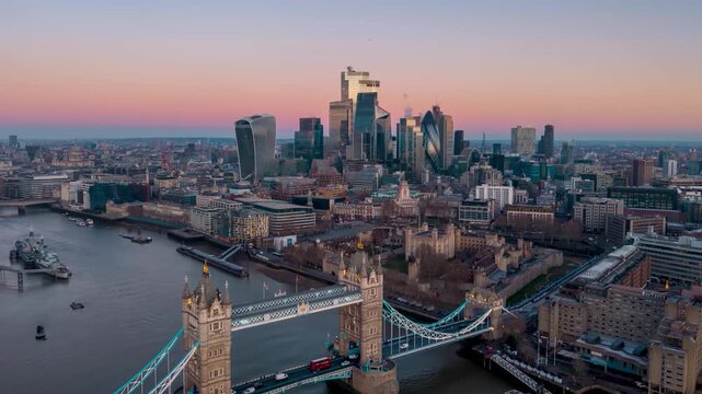Aerial hyperlapse view of the Tower Bridge and skyline of London, England, during golden dawn