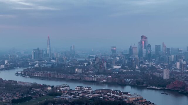 Moody night o day time lapse view of the skyline of London, England, during winter time with mist, fog and sunshine