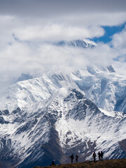 Naklejka premium Majestic Mount Gongga (Shushan King) Peeking Through Clouds, Western Sichuan China - Hikers Admiring Iconic Himalayan Peak