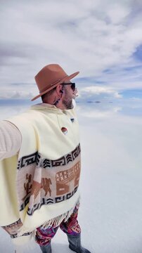 Happy Man in Traditional Poncho taking Selfie at Salar de Uyuni, Bolivia