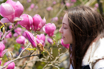 Naklejka premium Woman enjoying cherry blossoms in a tranquil Japanese garden. Blossom delight.