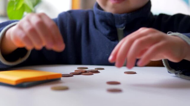Young Boy Counting and Sorting Coins on Table  &mdash; Child Financial Literacy, Early Numeracy, Pocket Money and Money Management Concept