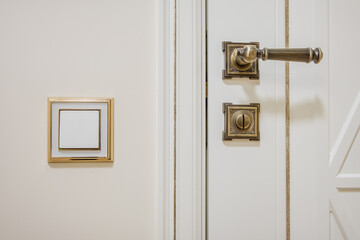 Fototapeta premium door handle and light switch next to it in a bright room or office