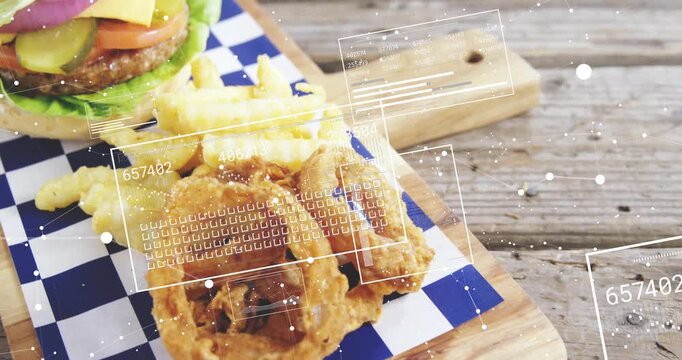 Camera panning aligning HUD overlay as burger fries onion-rings resting on wood board for food ad