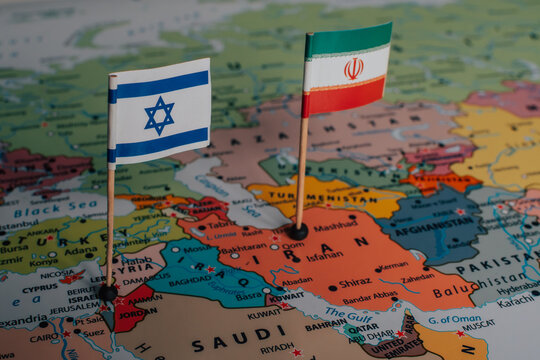 Close-up of Israeli and Iranian flags placed on a world map, illustrating geopolitical tensions in the Middle East