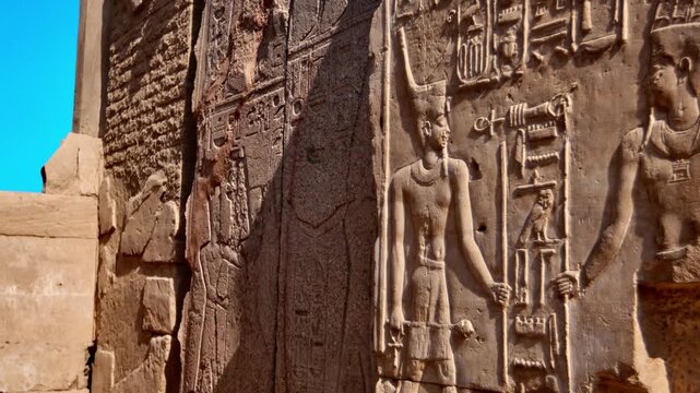 Karnak Temple in Luxor, Egypt. Close-up ancient Egyptian wall relief with pharaoh and gods figures, cartouche and hieroglyphics at Karnak Temple Luxor. Authentic history and documentary.
