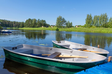 Obraz premium Plastic rowing boats at the river pier are ready for water trips, waiting for tourists.